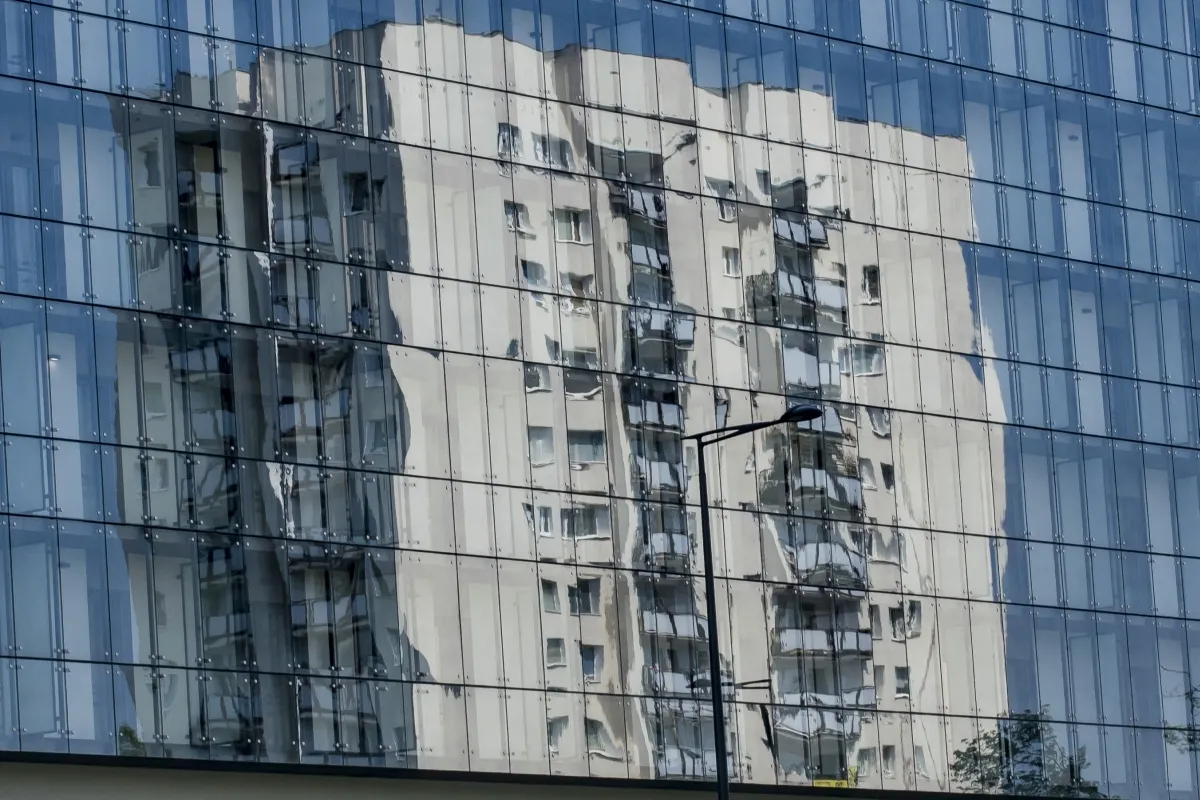 Modern glass facade reflecting another building and windows